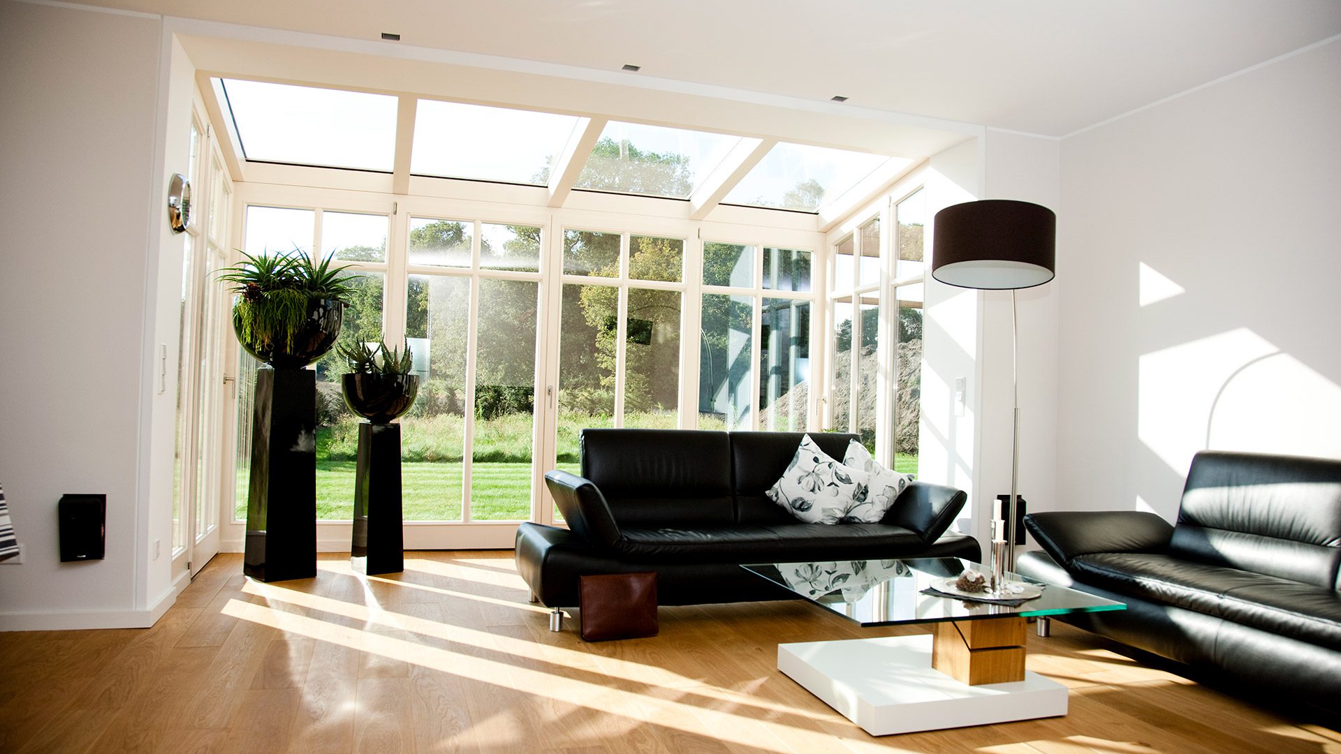 großes Wohnzimmer mit Glasfront und Glasdach